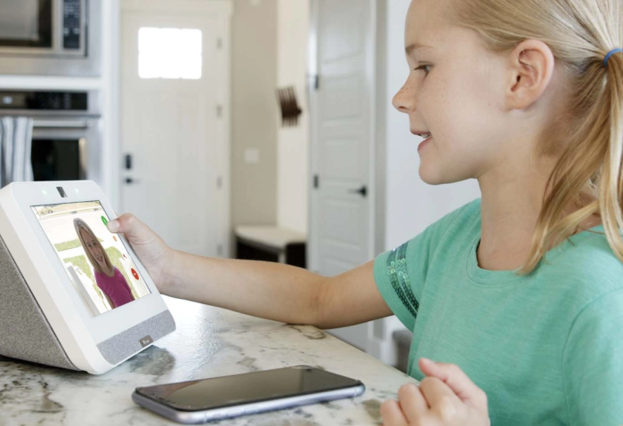 Young girl answering doorbell camera on home security system control panel display