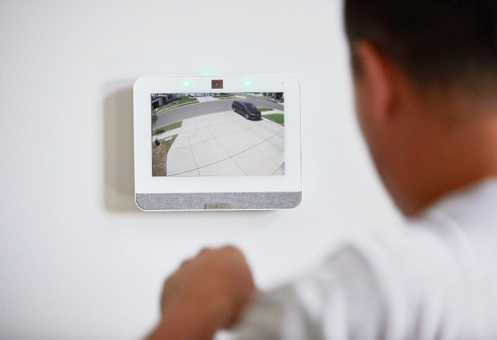 Man viewing smarthome security system control panel connected to a security camera monitoring his driveway