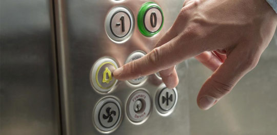 Elevator alarm button being pushed