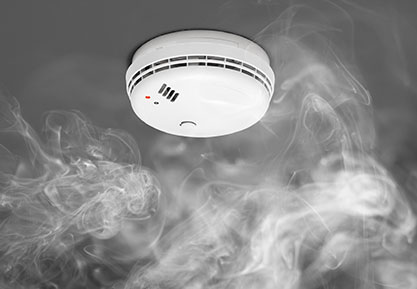 Smoke wafting up to smoke detector to show home fire protection system in action